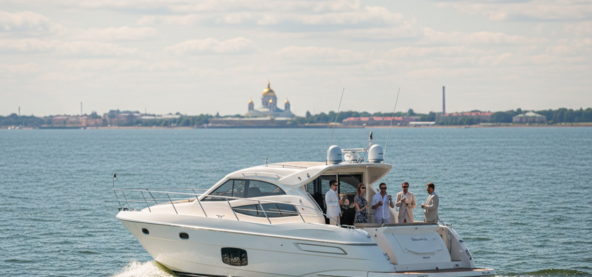Моторная яхта длиной около 18 метров идёт по открытой воде Финского залива в сторону Кронштадта